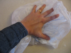Pressing the air out of a plastic grocery bag to make your own ice pack. Dr. Johnson of Peoria, IL.